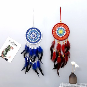 Detailed close-up of handmade dreamcatchers with colorful feathers and wooden beads
