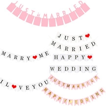Close-up of pink and white 'Just Married' and 'Marry Me' paper banners for wedding decor