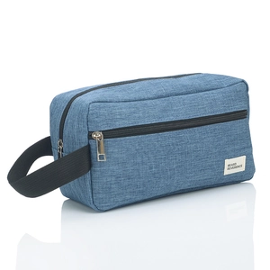 Detail of blue linen-textured toiletry bag with woven handle and zippered front pocket