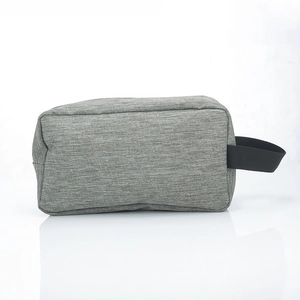 Side view of a grey large capacity travel toiletry bag with black webbing handle