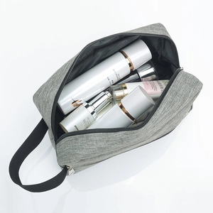 Grey fabric toiletry bag with black handle and silver zipper, spacious travel storage