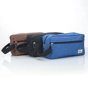 Detailed view of large travel toiletry bags in brown black and blue with side handles