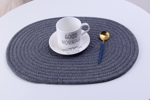 Detail shot of a dark gray hand-woven cotton rope oval heat-resistant dining placemat