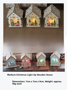 Close-up of laser-cut wooden Christmas house ornaments with warm LED lights