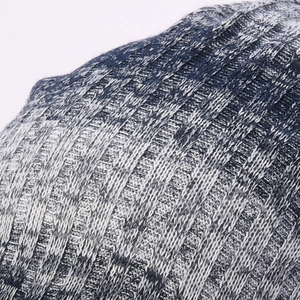 Detailed close-up of blue and white gradient ribbed knit fabric on a winter beanie hat