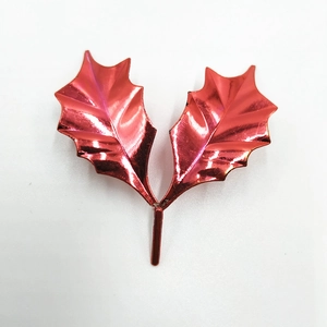 Macro view of metallic red holly leaves for DIY Christmas cake and gift decoration