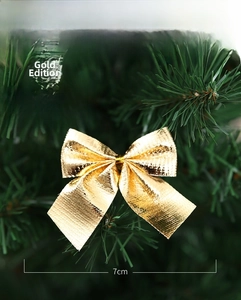 Détail de nœuds de Noël dorés de 7x6cm décorant des branches de sapin vert vif