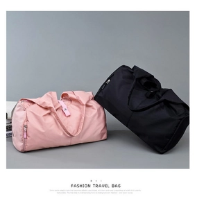 Detail of pink and black foldable travel bags showing waterproof nylon and metal zippers