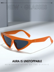 Detail of orange triangular cat-eye sunglasses with gold metal studs and grey lenses