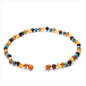 Macro detail of natural amber and turquoise beads on a colorful baby necklace
