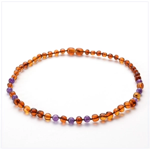 Macro view of natural baltic amber and amethyst beads on baby teething necklace