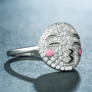 Vue macro d'une bague emoji bisou en argent avec cristaux pavés et joues roses rondes