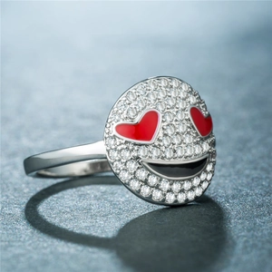 Détail macro d'une bague emoji en argent avec yeux en cœur rouge et zircons étincelants