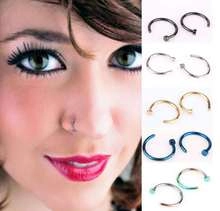 Detail view of colorful stainless steel nose rings on a model and flat lay