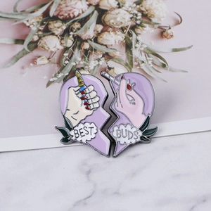 Detail showing Best Buds purple enamel pins on a pink floral background
