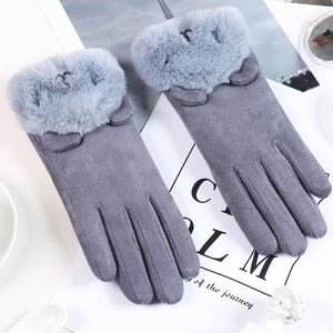 Detail grauer Wildlederimitat-Winterhandschuhe mit Plüsch-Katzenohren auf einem Magazin