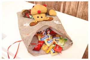 Close-up of Christmas burlap gift bag featuring a plush reindeer doll and drawstring