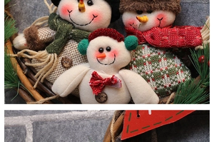 Detail of three handmade snowman plush dolls with hats and scarves in a rustic basket