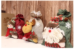 Detail of Christmas burlap drawstring gift bags with 3D snowman, reindeer, and Santa motifs