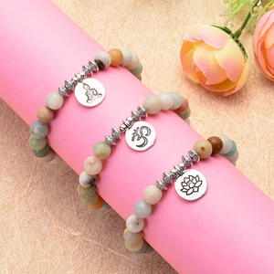 Amazonite yoga bead bracelets with lotus, Om, and Buddha charms on a display stand