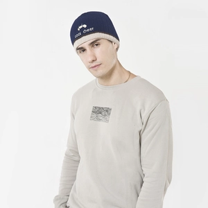 Close-up of navy blue knit beanie with cool cheer embroidery and minimalist gray sweatshirt