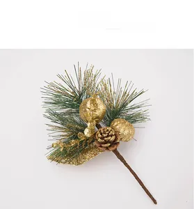 Detail of Christmas pick featuring green pine needles, gold glitter balls, and a pine cone