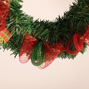 Couronne de Noël avec aiguilles de pin vertes, nœuds en maille rouge et cadeaux décoratifs