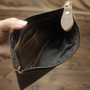 Close-up of brown crazy horse leather wallet showing internal card slots and metal zipper