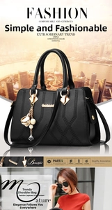 Detailed view of black lychee leather handbag featuring floral charm and metal logo detail