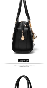Detail view of black lychee leather bag featuring gold hardware and floral rhinestone charm