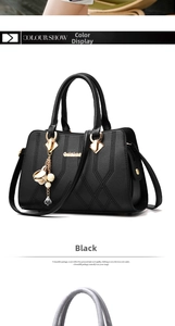 Detailed close-up of black litchi PU leather texture with gold logo and floral bag charm