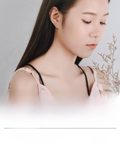 Detail of minimalist hollow cat outline stud earring worn by a model in silver finish