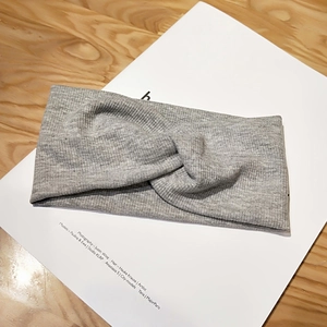 Detailed view of the light grey heather knit fabric and twisted knot on the headband