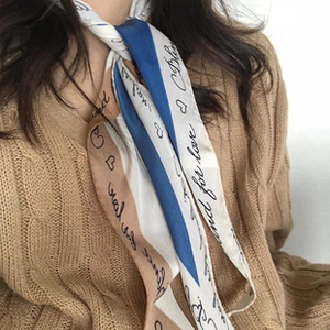 Close-up of tricolor twill silk scarf with 'and for love' cursive pattern on female model