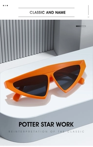 Close-up of bright orange triangle sunglasses on a geometric platform for a trendy look