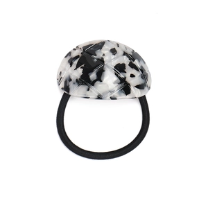 Detail view of monochrome tortoiseshell acetate hair tie with quilted grid pattern