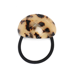 Detail of tortoiseshell acetate hair tie with quilted pattern and black elastic band