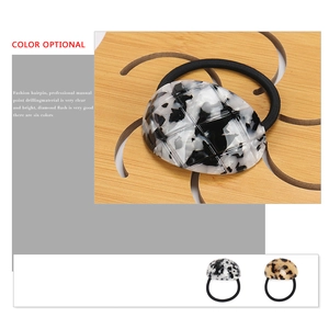 Elegant checkered pattern acetate hair tie with round ornament on wooden base