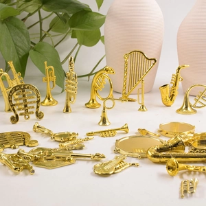 Detailed view of miniature gold musical instruments for Christmas cake and floral decor