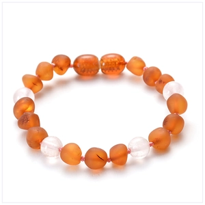 Detailed view of Baltic amber beads mixed with amethyst stones on a white background