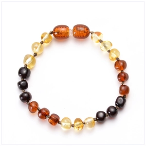 Macro view of Baltic amber baby bracelet with multi-color beads on white background