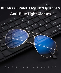 Detailed view of silver metal aviator glasses with blue light blocking lenses on a keyboard