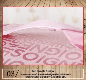 Close-up of pink fabric vanity bag showing reinforced soft handle and letter jacquard