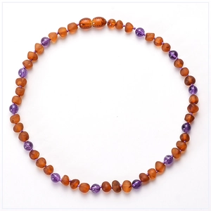 Detail of baby necklace with Baltic amber chips and purple amethyst round beads