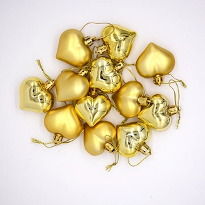 Golden heart-shaped Christmas ornaments in matte and glossy finishes on white background