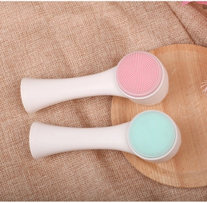 Detail of pink and mint green double-sided silicone facial brushes with white handles