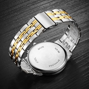 Detail of stainless steel case back with two-tone gold and silver link bracelet