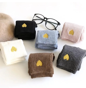 Detailed view of folded ribbed knit socks with delicate gold heart embroidery in six colors