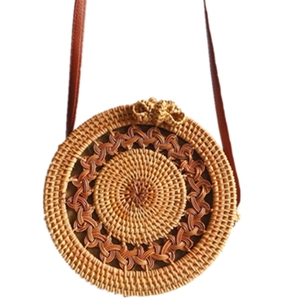 Handmade round rattan crossbody bag with woven texture and brown leather strap