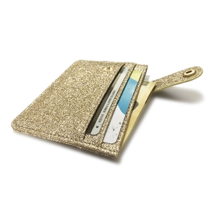 Detailed side view of golden sequin card holder featuring snap closure and card slots